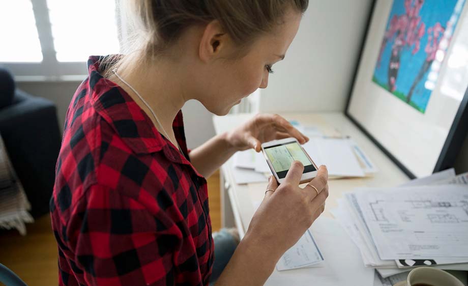 Young woman taking a photo of a check for a mobile deposit