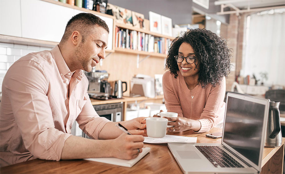 Couple at kitchen table reviewing their bills