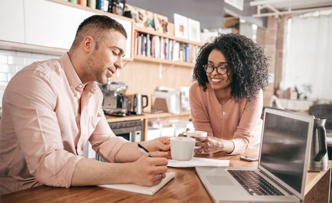 Couple at kitchen table reviewing their bills