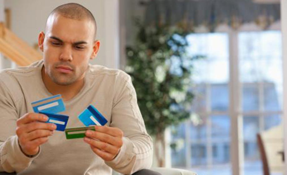 Man holding four credit cards