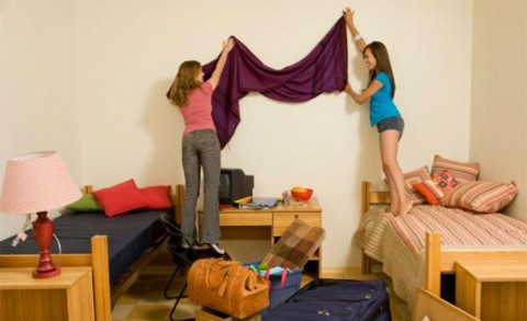 Two girls decorating a dorm room