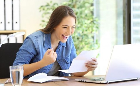 Happy young woman at her laptop