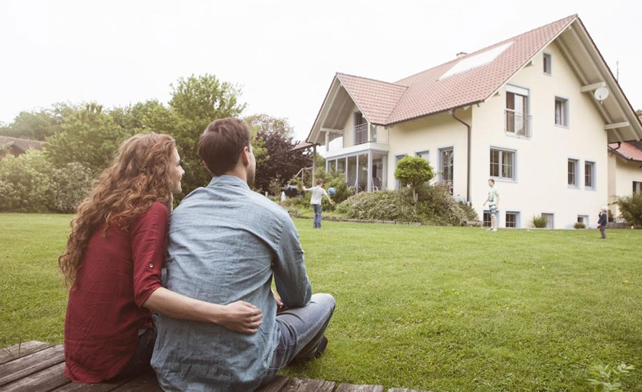 Couple sitting in the yard of their new home