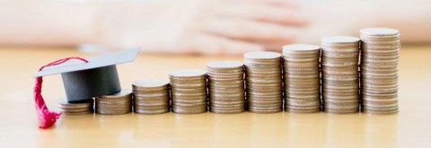 Ascending piles of coins with a mortarboard and tassel